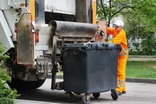 Operative wearing PPE while loading a waste vehicle during clearance